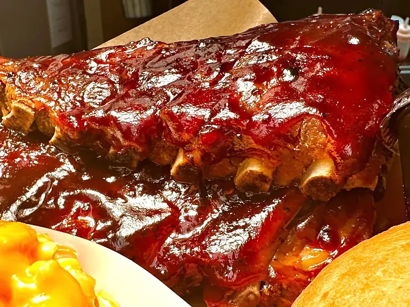 Baby back ribs in sweet BBQ sauce with macaroni and cheese and a dinner roll